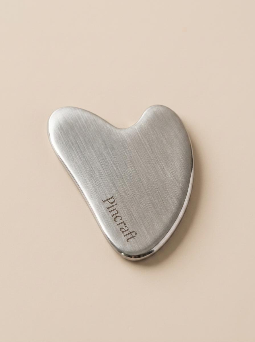 Pincraft heart-shaped gua sha tool in polished stainless steel
